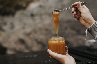 Hands holding jar with honey