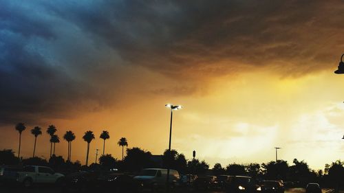 Low angle view of illuminated street light against cloudy sky