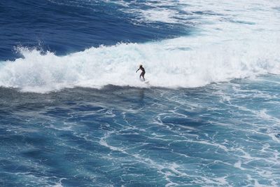 High angle view of man surfing in sea against sky