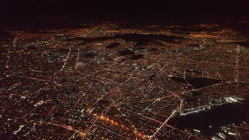 High angle view of illuminated cityscape against sky at night