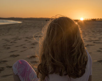 Close-up of woman at beach against sky during sunset