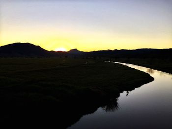 Scenic view of agricultural landscape against sky during sunset