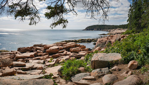 Rocks by sea against sky