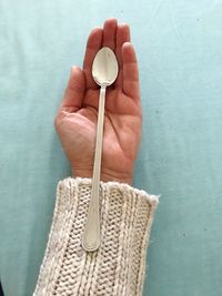 Close-up of human hand holding spoon on table