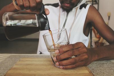 Midsection of man pouring coffee