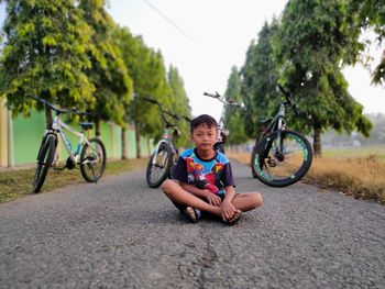 Portrait of boy riding bicycle on road