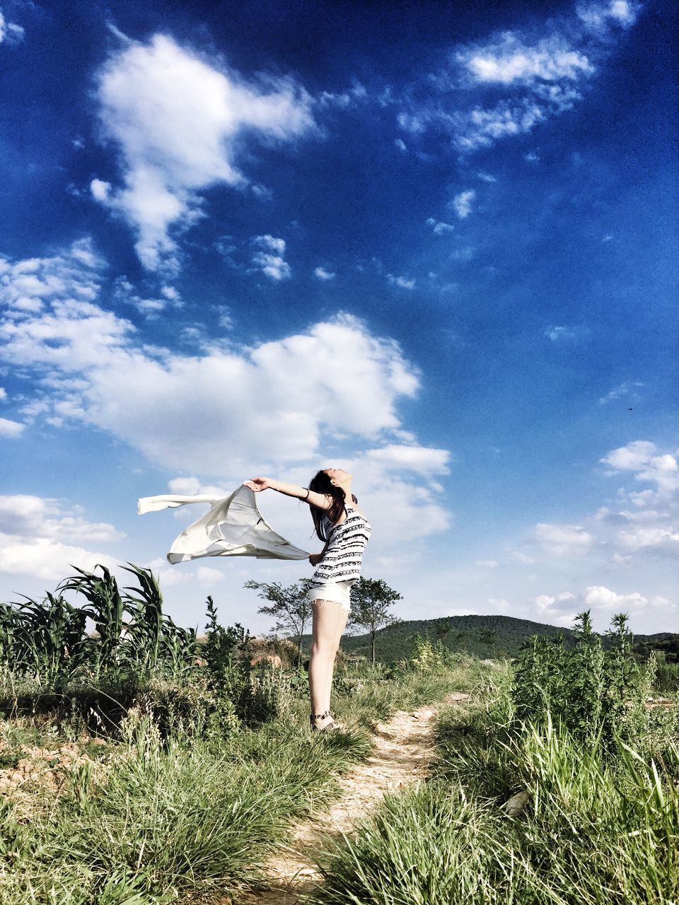 sky, grass, full length, leisure activity, lifestyles, rear view, cloud - sky, casual clothing, tranquility, tranquil scene, field, standing, cloud, person, nature, landscape, scenics, men