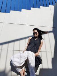 Young woman standing against wall