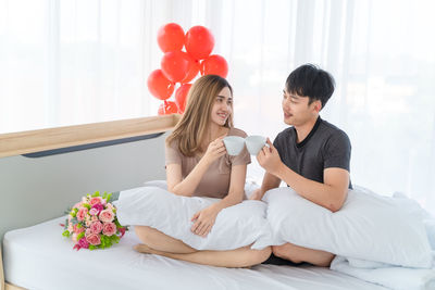 Couple sitting on bed at home