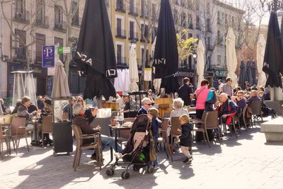 People on street amidst buildings in city