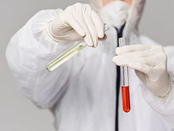 Midsection of scientist working against white background