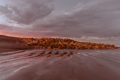 Scenic view of sand dune on beach against sky