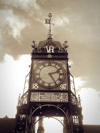 Low angle view of clock tower against cloudy sky