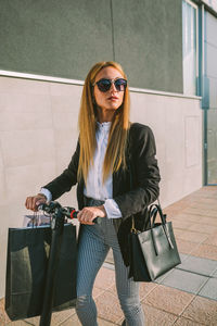 Young woman wearing sunglasses sitting outdoors