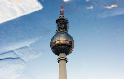 High angle view of fernsehturm against sky reflecting in puddle