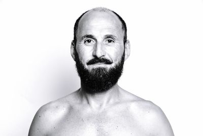 Portrait of shirtless man standing against white background