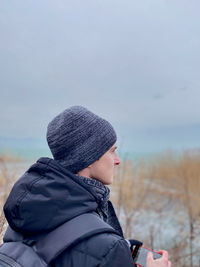 Portrait of person wearing hat against sky during winter