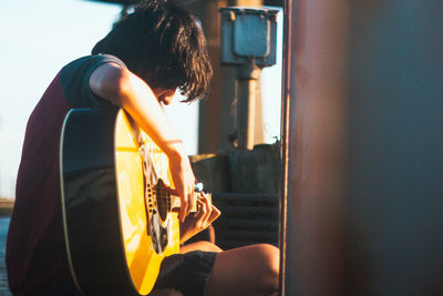 Side view of woman playing guitar