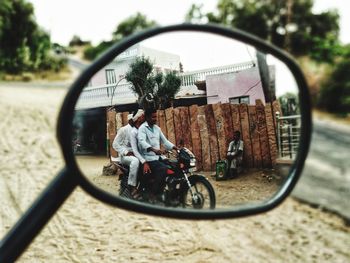 Man riding motorcycle on side-view mirror