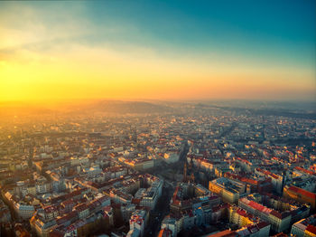 High angle view of city buildings against sky during sunset