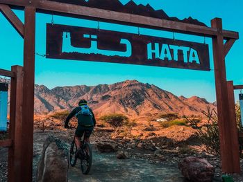 Rear view of man riding bicycle on mountain