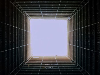 Low angle view of tall building against clear blue sky