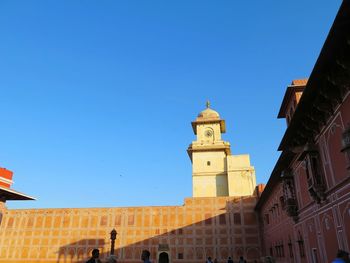 Low angle view of bell tower against clear blue sky