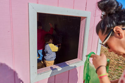 Kids running around and coloring in a chalk house at the farm fair on halloween