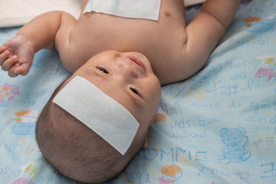 High angle view of baby lying on bed