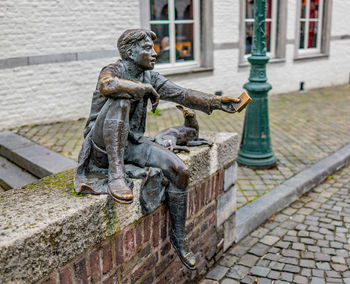 Statue by street against building