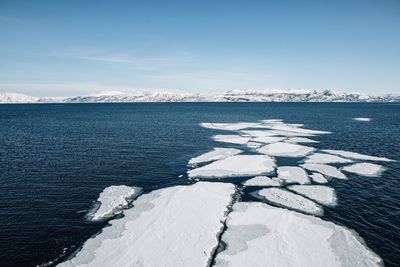 Frozen sea against sky during winter