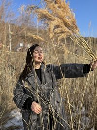 Portrait of young woman standing on field