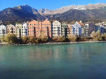 Houses by lake and buildings in city