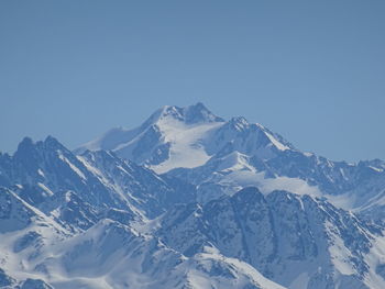 Scenic view of snowcapped mountains against clear blue sky