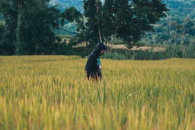 Rear view of woman walking on field