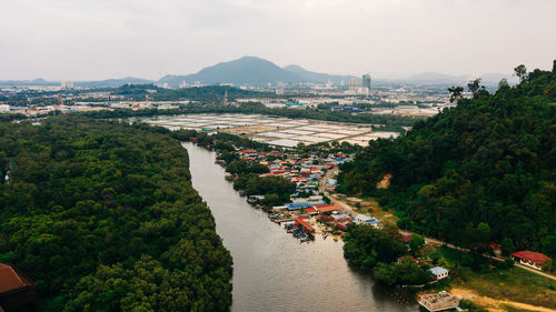 High angle view of river amidst city against sky