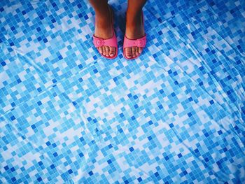 Low section of woman standing on swimming pool