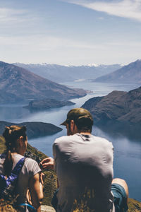 Rear view of people on lake against mountain range
