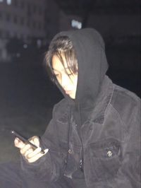 Portrait of woman holding camera while standing at night