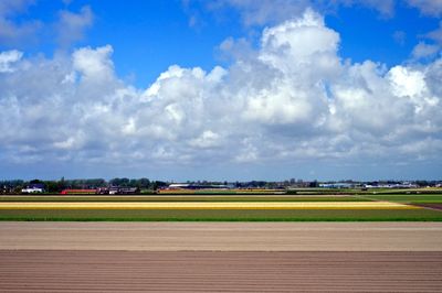 Agricultural field against cloudy sky