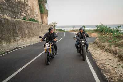 Side view of man riding motorcycle on road