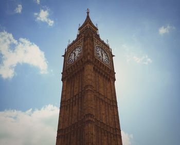 Low angle view of clock tower against cloudy sky