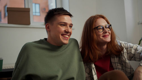 Young smiling couple sitting at home