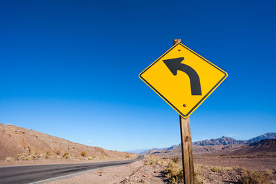 Road sign against blue sky