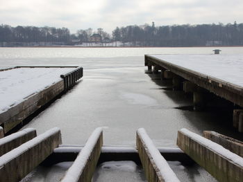 Pier over lake against sky during winter