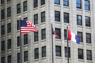 Low angle view of flag against buildings in city