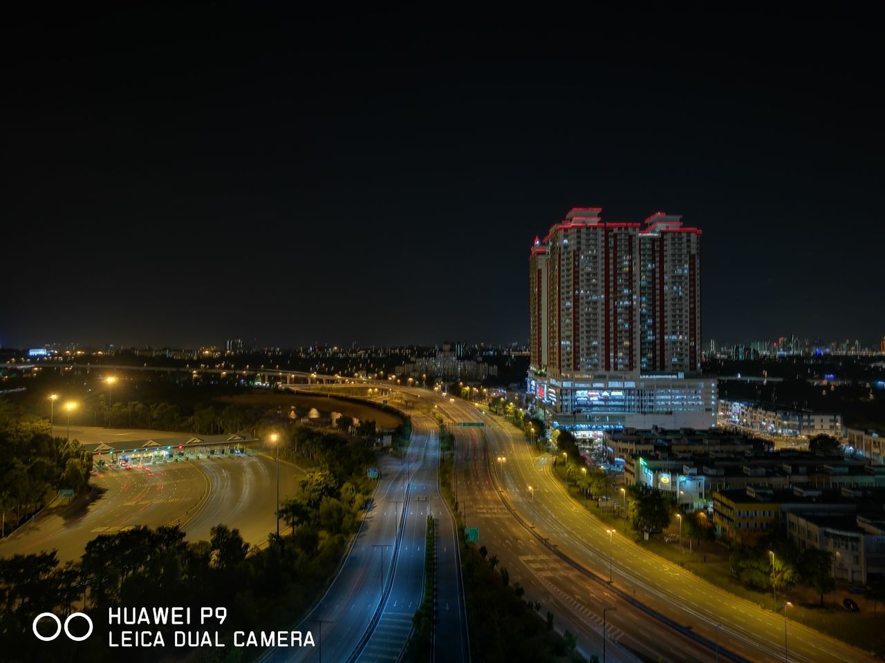 illuminated, night, architecture, built structure, transportation, city, building exterior, high angle view, road, bridge - man made structure, water, mode of transport, light trail, river, travel destinations, outdoors, sky, engineering, city life, skyscraper