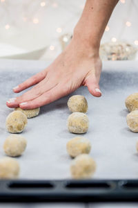 Close-up of hand pressing food on baking sheet