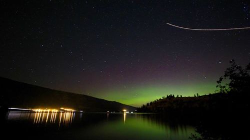 Scenic view of lake against sky at night