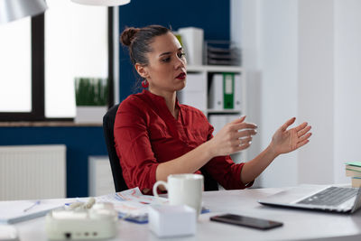 Businesswoman talking on video call at office